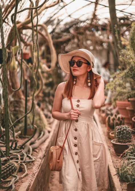 woman wearing sleeveless dress walking near cactus plants